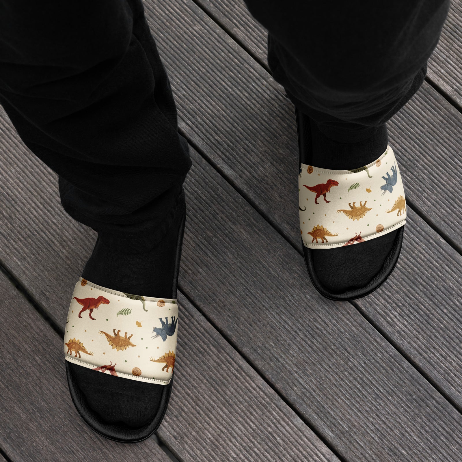 Man wearing Fossil Botanica dinosaur slides with a natural-history dinosaur print strap