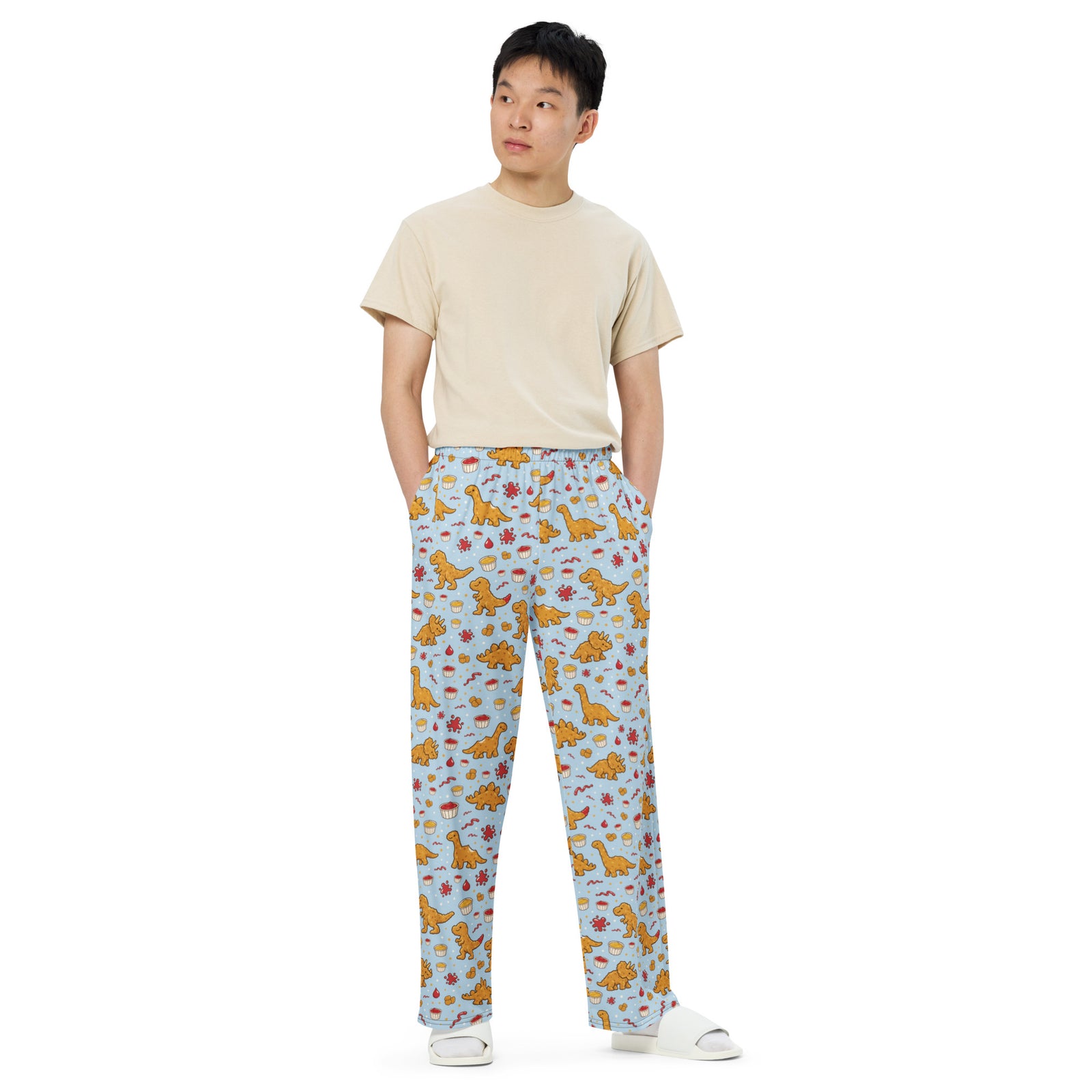 Model wearing Dino Nuggies adult dinosaur pajama pants, front view