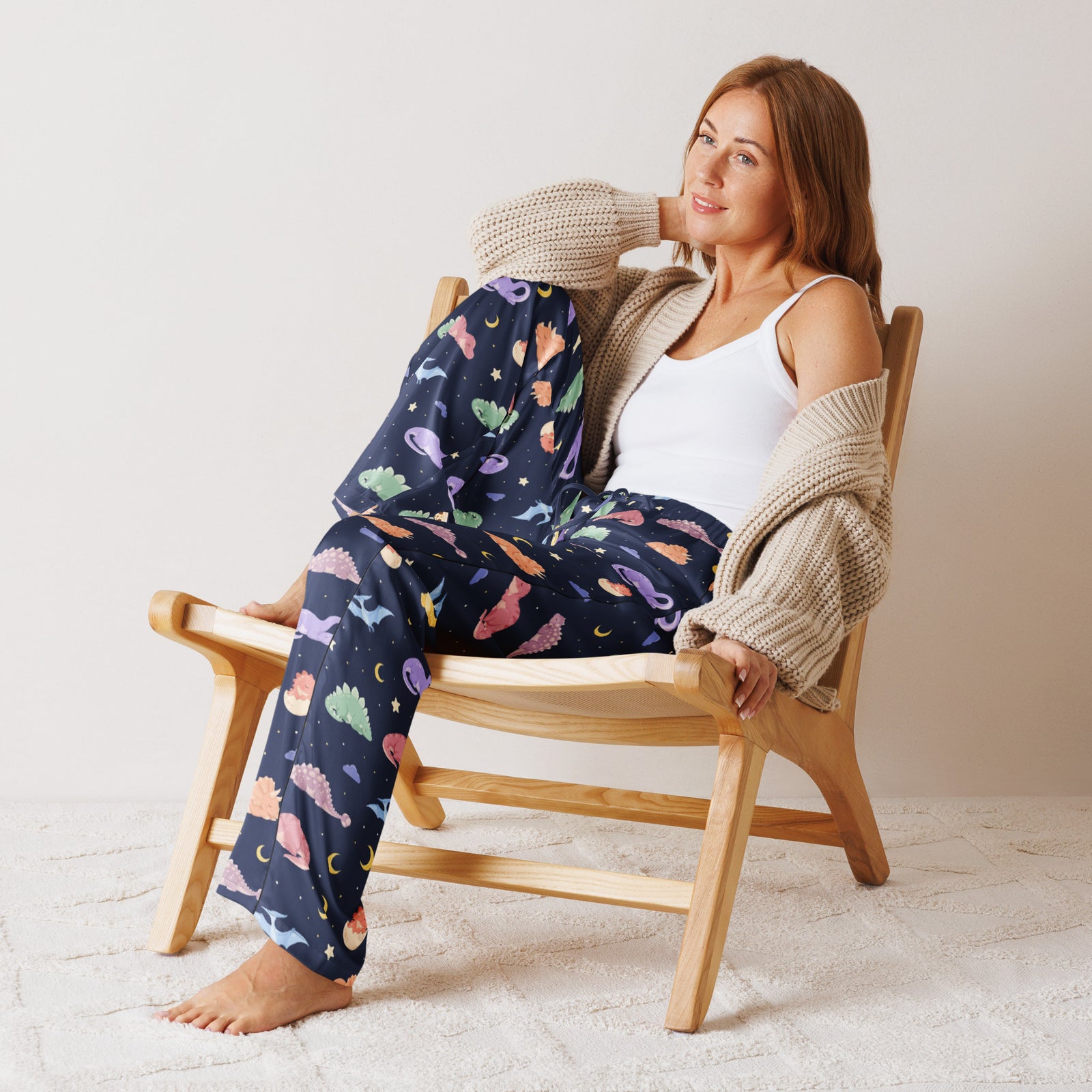 Woman wearing Sleepy Dinos women's dinosaur pajama pants - midnight navy with sleeping pastel dinosaurs, moons and stars - front view
