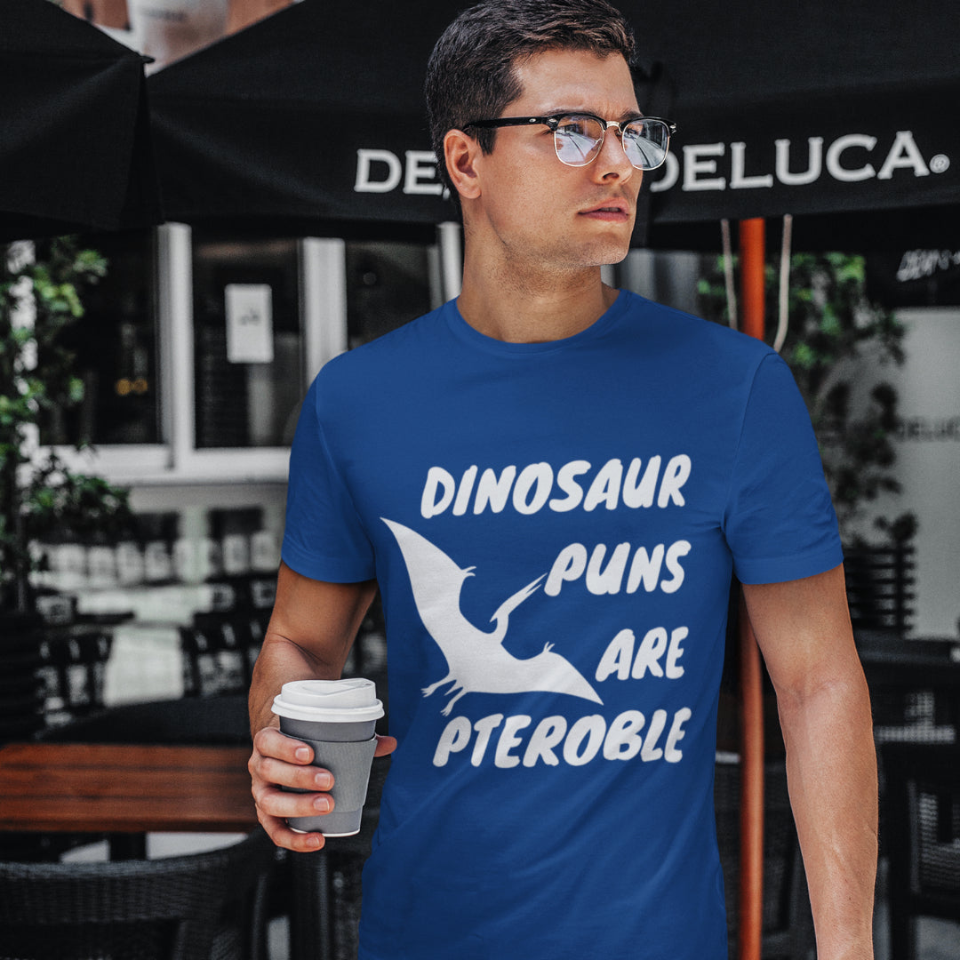 Man wearing a blue dinosaur t-shirt that says "Dinosaur Puns Are Pteroble". 