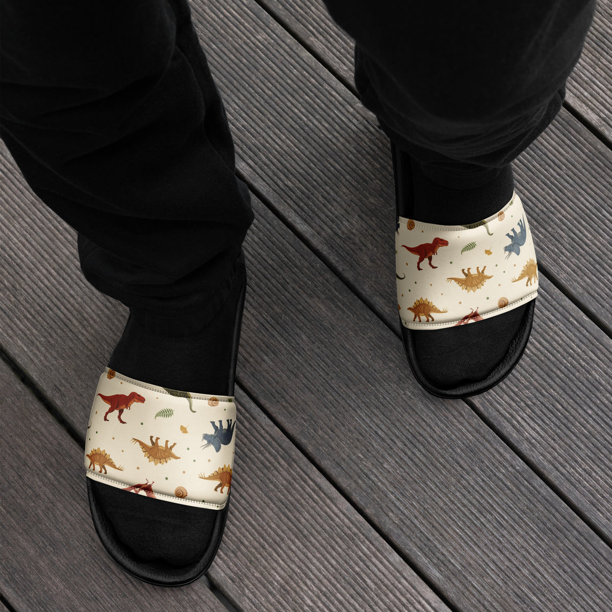 Man wearing Fossil Botanica dinosaur slides with a natural-history dinosaur print strap