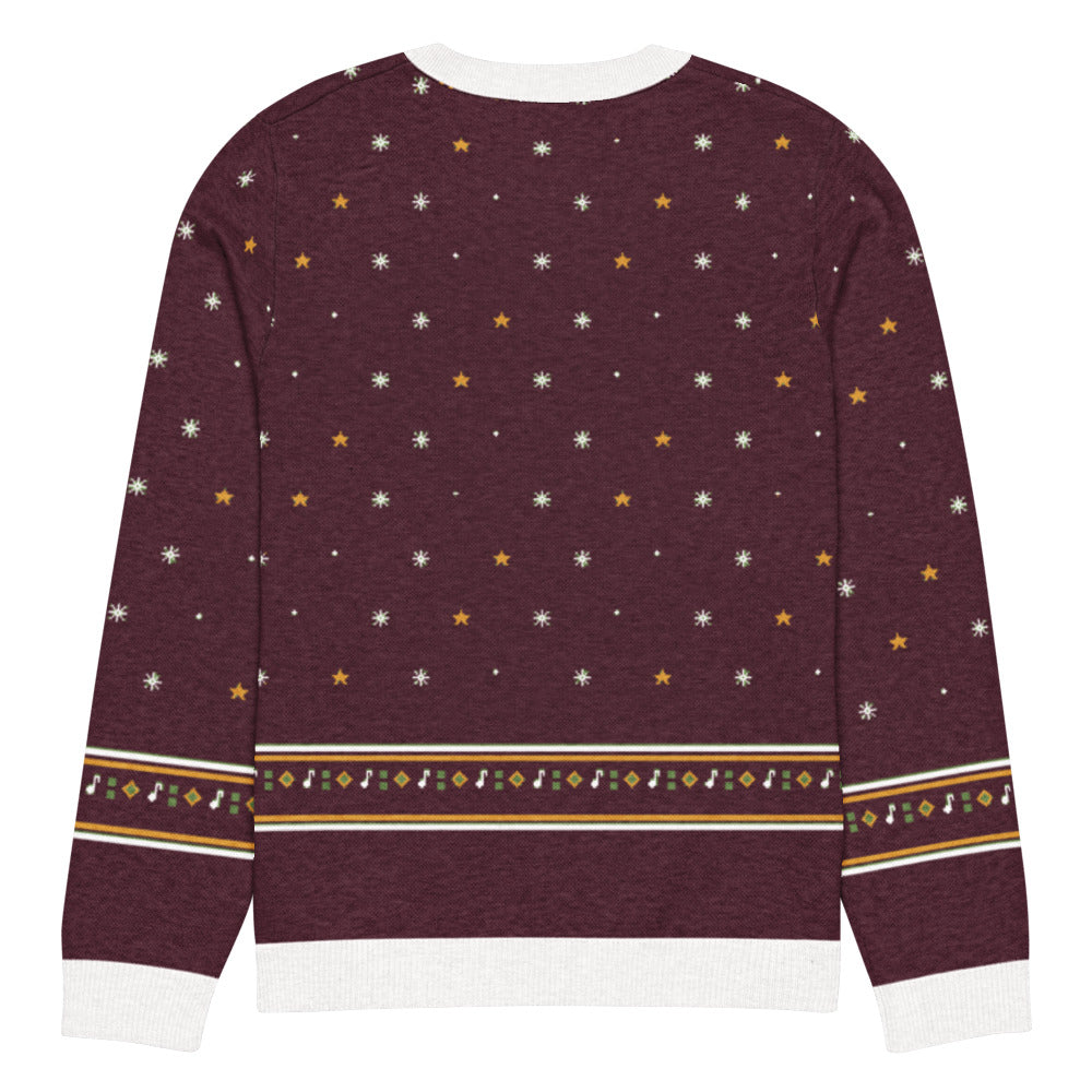 Back of the burgundy Fa La La La Roar knitted Christmas sweater with snowflakes, gold stars and a fair-isle diamond and music-note band above the white hem