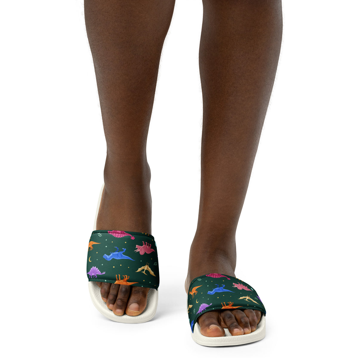 Woman wearing Emerald Jewel Dinos dinosaur slides with a jewel-tone dinosaur print strap
